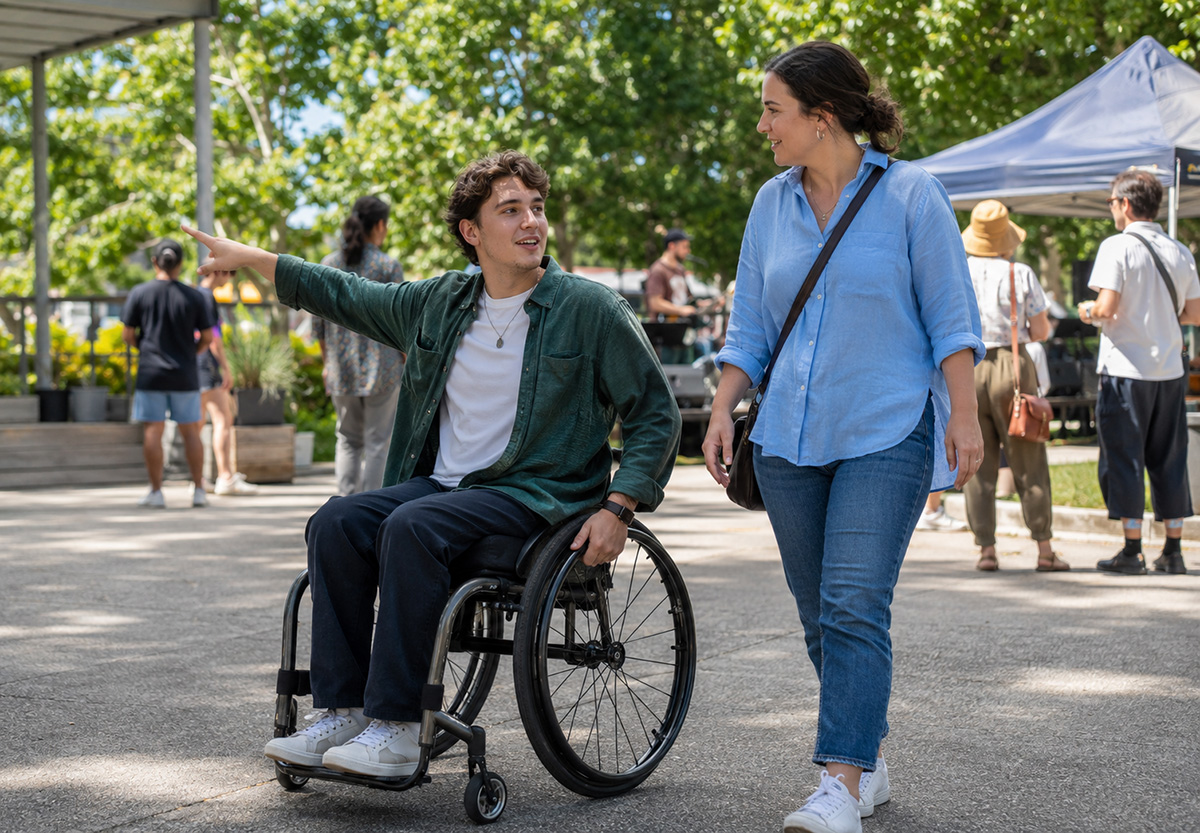 A wheelchair user and support worker enjoying an accessible community event in South-East Melbourne